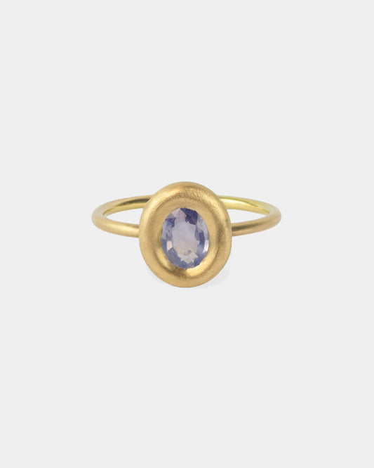 Bague Bouée de Vega en or avec un saphire bleu central, vue de face, montrant la monture arrondie minimaliste.