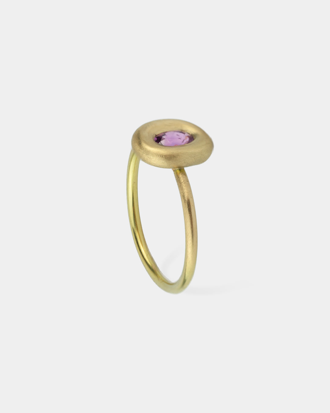 Bague Bouée de Vega en or, avec un saphir rose central, vue de côté, mettant en évidence la finesse de sa monture arrondie et minimaliste.