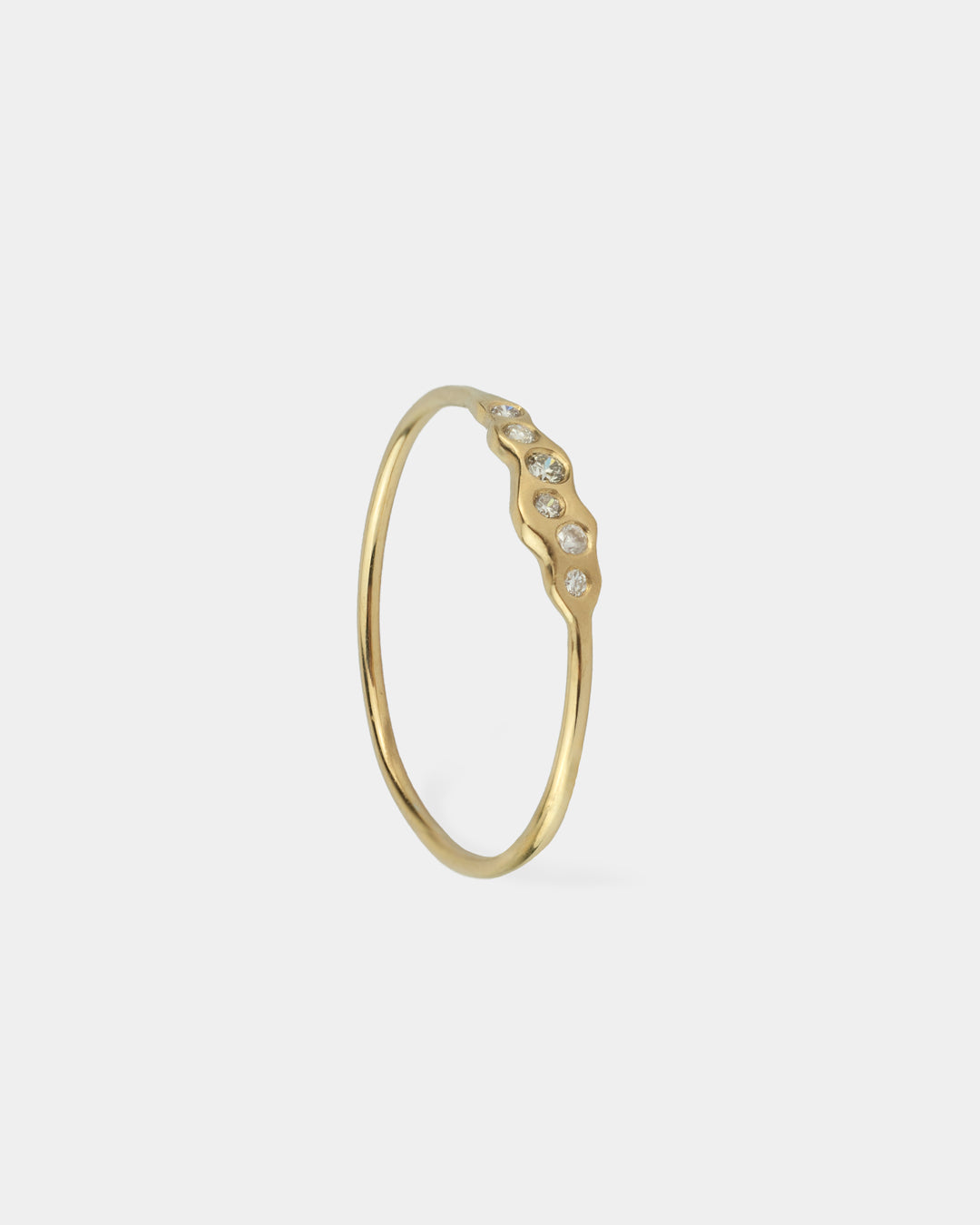 La bague Wave de Vega est une pièce en or jaune 18 carats avec des ondulations douces et fluides, ornementées de six diamants.